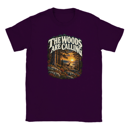 The Woods Are Calling - T-shirt in Maroon. A deer between tall pine trees in golden light beneath The Woods Are Calling lettering.