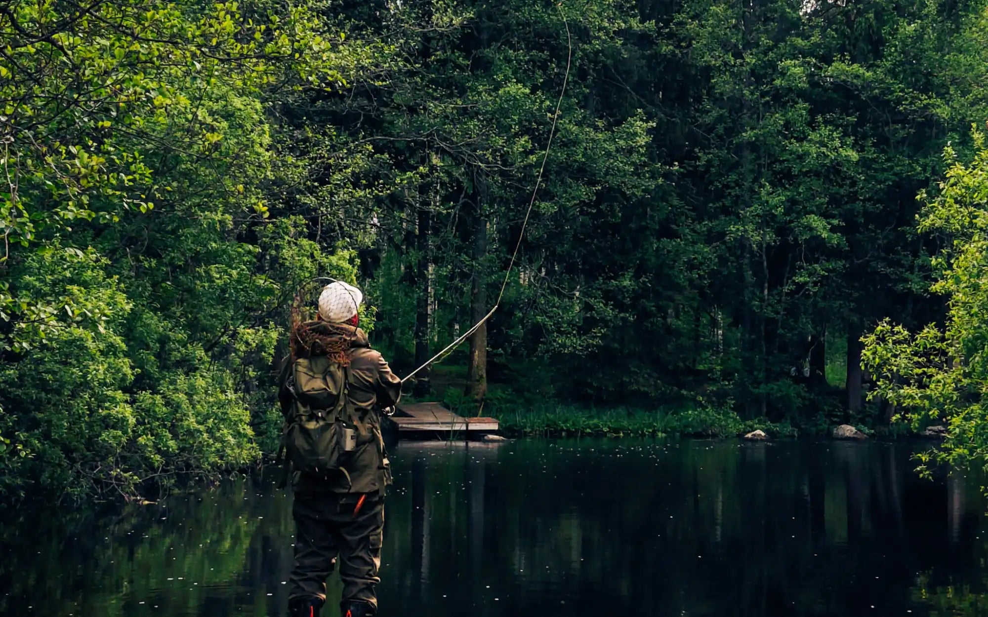 finnish river scenery. man standing in the river casting line and fishing. high quality shirts with text 