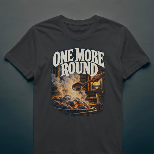Black t-shirt with the One More Round print: water hitting hot sauna stones, steam in a timber sauna and a lake sunset through the window